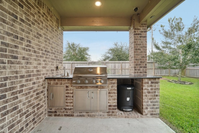 view of patio with an outdoor kitchen, area for grilling, and sink