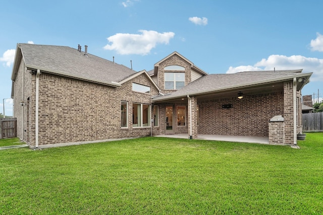 back of property with a lawn and a patio