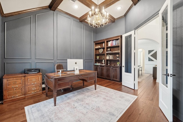 office space with beamed ceiling, dark hardwood / wood-style floors, french doors, and a chandelier