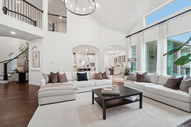 living room featuring crown molding, high vaulted ceiling, a chandelier, and dark hardwood / wood-style floors