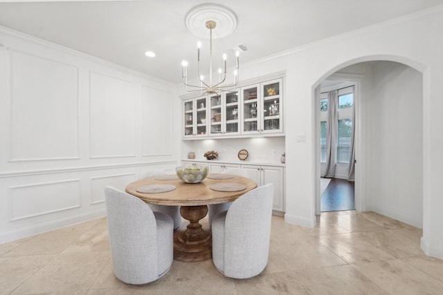 dining space with a chandelier and ornamental molding