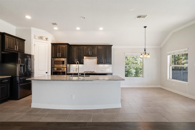 kitchen with appliances with stainless steel finishes, vaulted ceiling, a kitchen island with sink, and sink