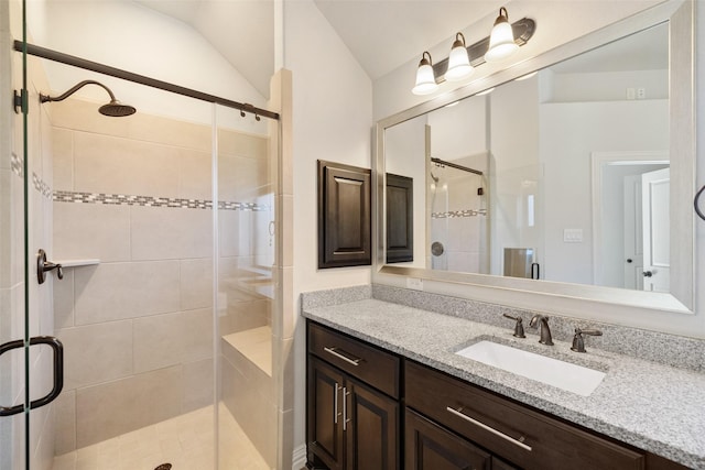 bathroom featuring vanity, an enclosed shower, and lofted ceiling