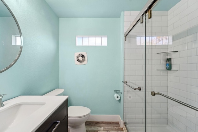 bathroom featuring toilet, hardwood / wood-style flooring, an enclosed shower, and vanity