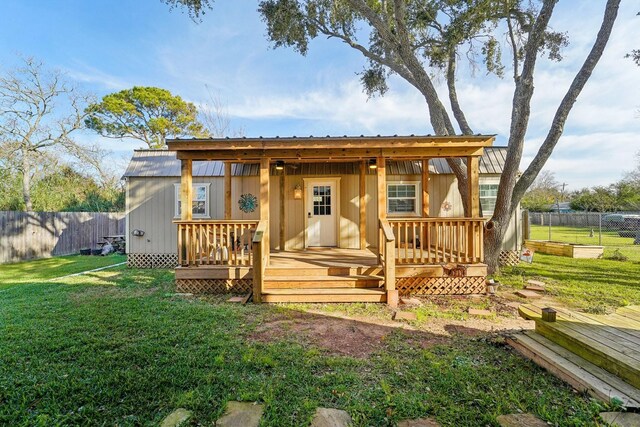 rear view of house featuring a deck and a yard