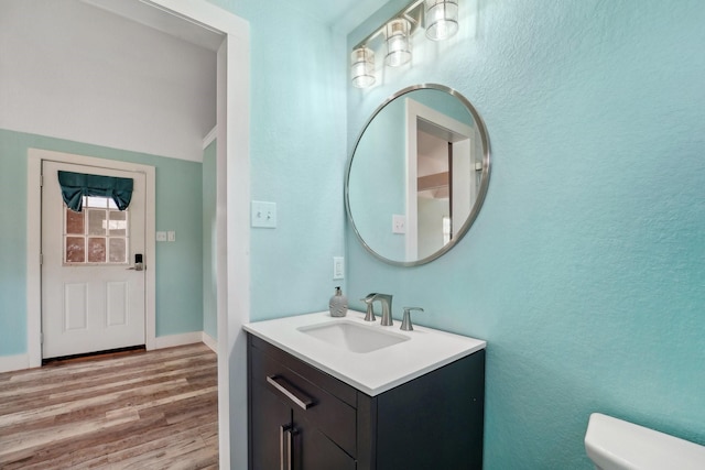 bathroom featuring toilet, hardwood / wood-style flooring, and vanity