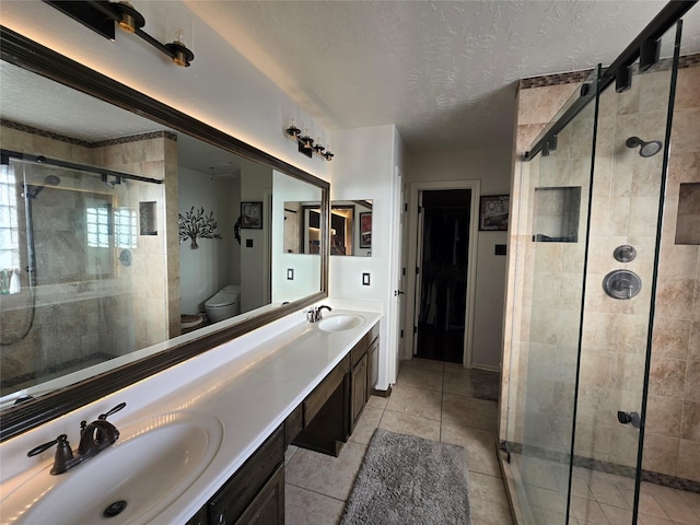 bathroom featuring vanity, a shower with door, tile patterned floors, toilet, and a textured ceiling