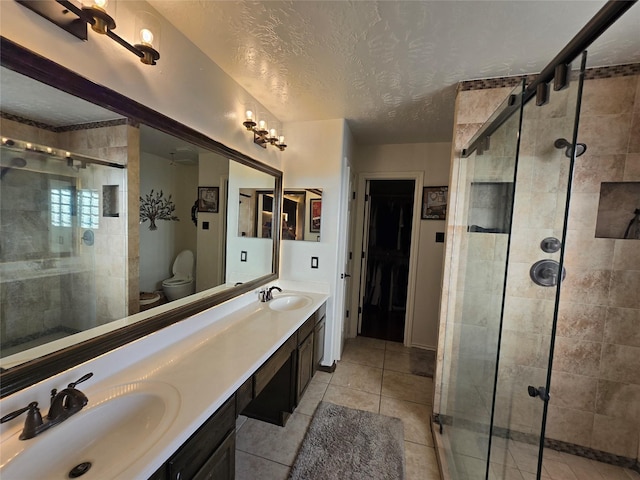 bathroom with vanity, a textured ceiling, toilet, and a shower with door