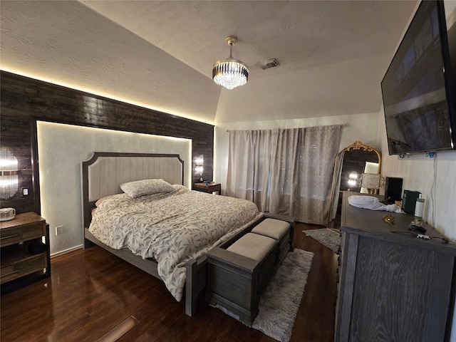 bedroom featuring dark hardwood / wood-style flooring, a chandelier, and vaulted ceiling