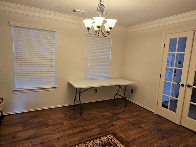 dining room featuring dark hardwood / wood-style flooring, french doors, crown molding, and an inviting chandelier