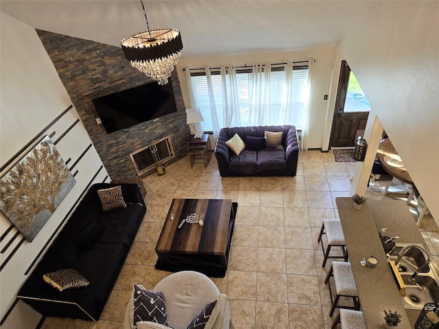 living room featuring a fireplace, light tile patterned floors, and a notable chandelier