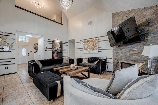 living room featuring a notable chandelier, a fireplace, a textured ceiling, light tile patterned flooring, and vaulted ceiling