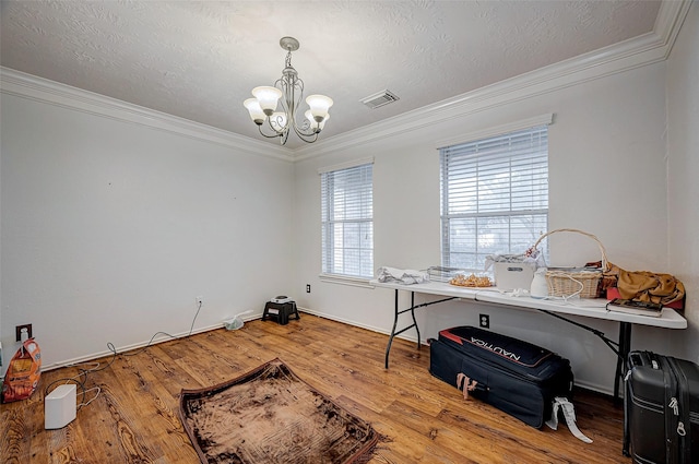 interior space with ornamental molding, wood-type flooring, a chandelier, and a textured ceiling