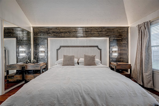 bedroom featuring lofted ceiling, a textured ceiling, and dark hardwood / wood-style flooring