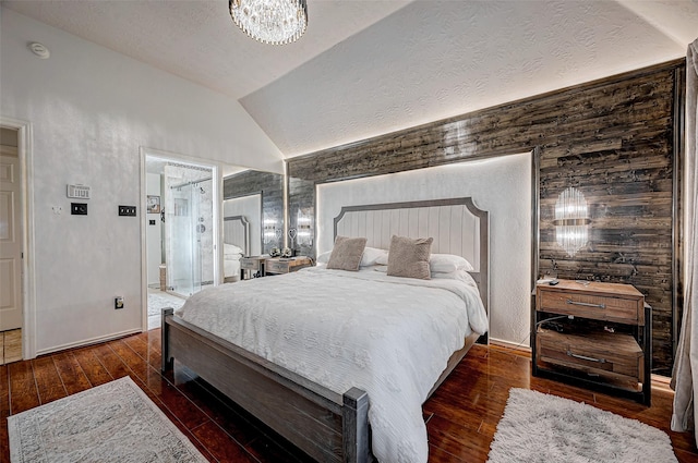 bedroom with vaulted ceiling, dark hardwood / wood-style floors, an inviting chandelier, and a textured ceiling