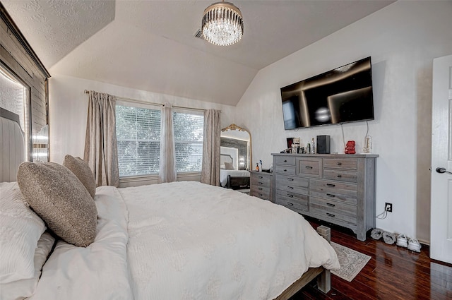 bedroom featuring a notable chandelier, dark wood-type flooring, and vaulted ceiling