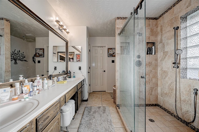 bathroom with vanity, tile patterned floors, an enclosed shower, and a textured ceiling