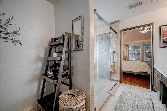 bathroom with vanity, tile patterned floors, a textured ceiling, and walk in shower