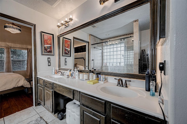 bathroom with vanity, tile patterned flooring, a textured ceiling, and a tile shower