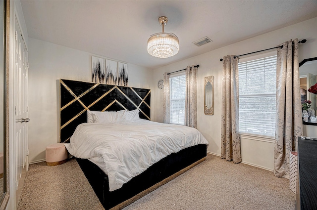 bedroom with carpet and a notable chandelier