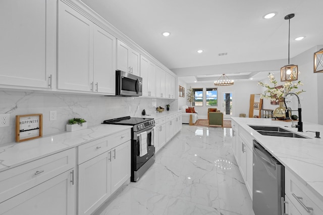 kitchen featuring light stone countertops, appliances with stainless steel finishes, sink, pendant lighting, and white cabinets