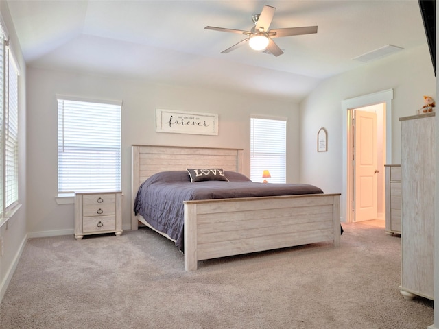 bedroom with ceiling fan, multiple windows, light carpet, and vaulted ceiling