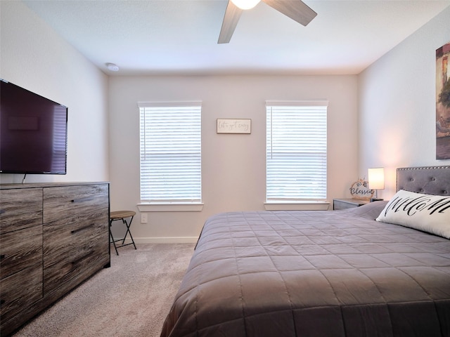 bedroom featuring multiple windows, ceiling fan, and carpet