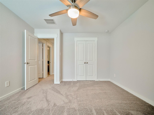 unfurnished bedroom featuring ceiling fan, a closet, and light colored carpet