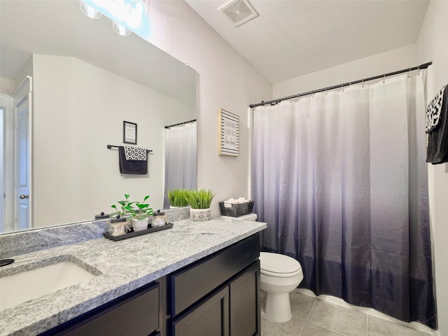 bathroom with tile patterned floors, vanity, a textured ceiling, and toilet