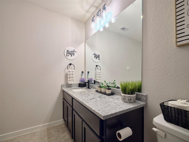 bathroom with tile patterned flooring, vanity, and toilet