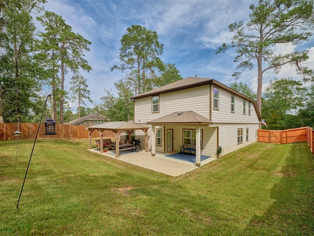 back of house featuring a gazebo, a patio area, and a lawn