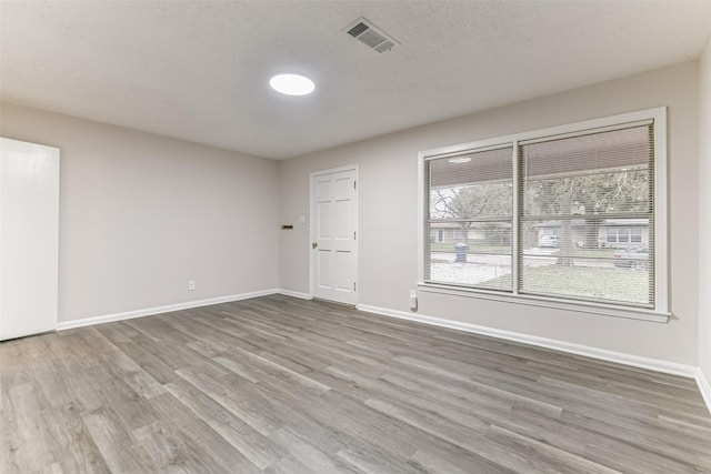 spare room with hardwood / wood-style floors and a textured ceiling