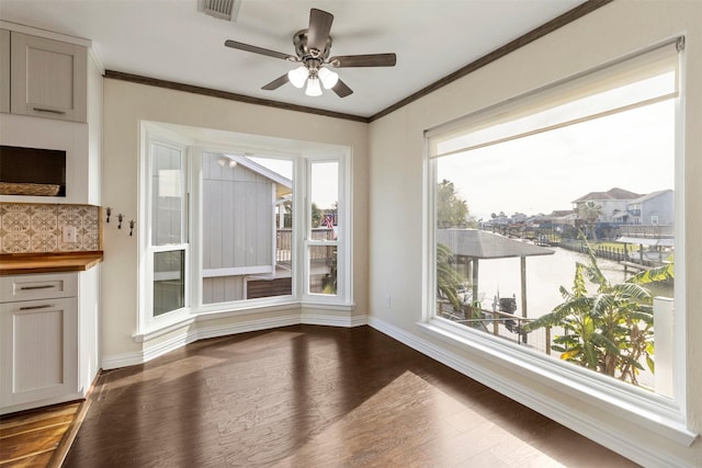 unfurnished dining area featuring hardwood / wood-style flooring, ceiling fan, and ornamental molding