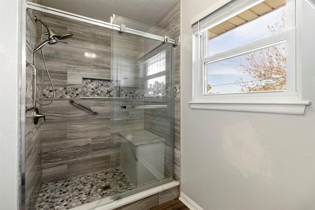 bathroom featuring a shower with door