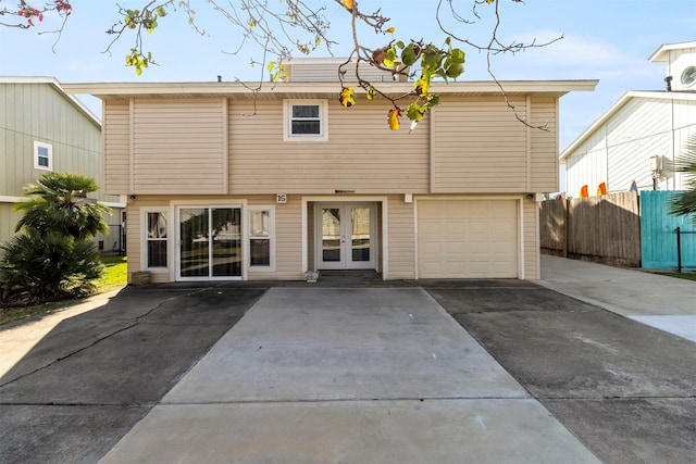 rear view of property featuring french doors and a garage