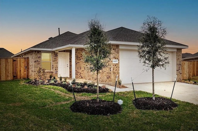 ranch-style home featuring a garage and a yard