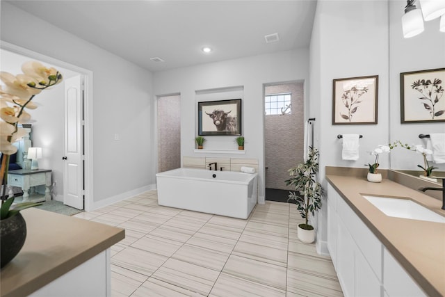 bathroom featuring a washtub, vanity, and tile patterned flooring