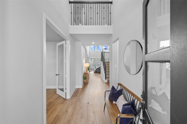 foyer entrance with light hardwood / wood-style flooring and a high ceiling