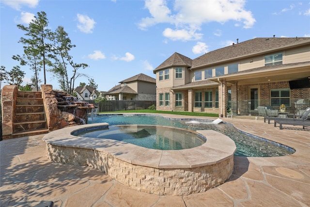 view of swimming pool featuring an in ground hot tub, pool water feature, and a patio area