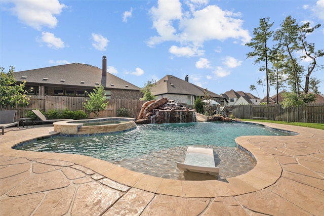 view of swimming pool featuring an in ground hot tub, pool water feature, and a patio area