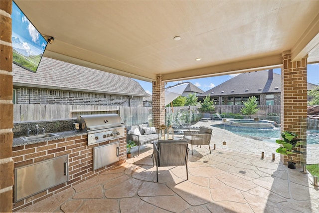 view of patio / terrace with a pool with hot tub, a grill, sink, and area for grilling