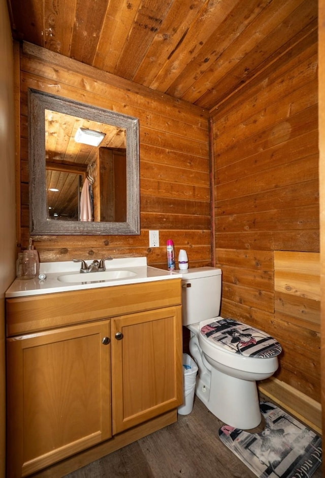 bathroom featuring vanity, wooden walls, wooden ceiling, hardwood / wood-style floors, and toilet