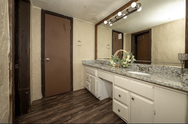 bathroom with vanity, a textured ceiling, and hardwood / wood-style flooring