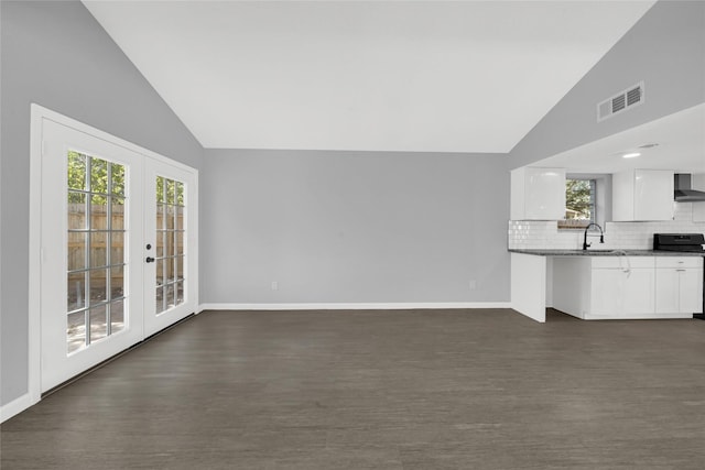 unfurnished living room with french doors, dark hardwood / wood-style flooring, vaulted ceiling, and sink