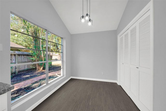 unfurnished dining area with dark hardwood / wood-style floors, a healthy amount of sunlight, and vaulted ceiling