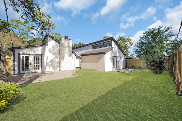 back of house with a yard, french doors, and a patio