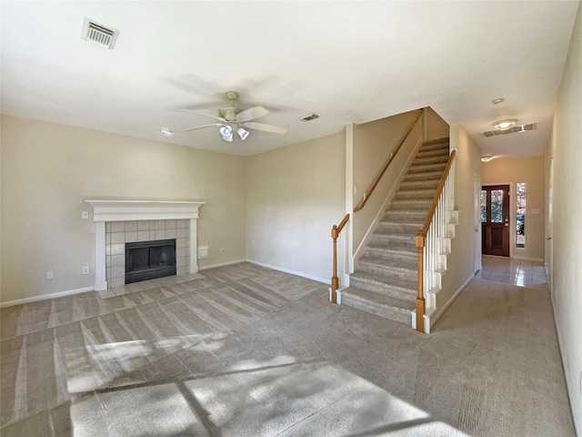 unfurnished living room with ceiling fan, light carpet, and a fireplace