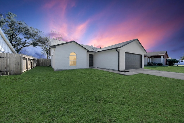 ranch-style home with a garage and a lawn