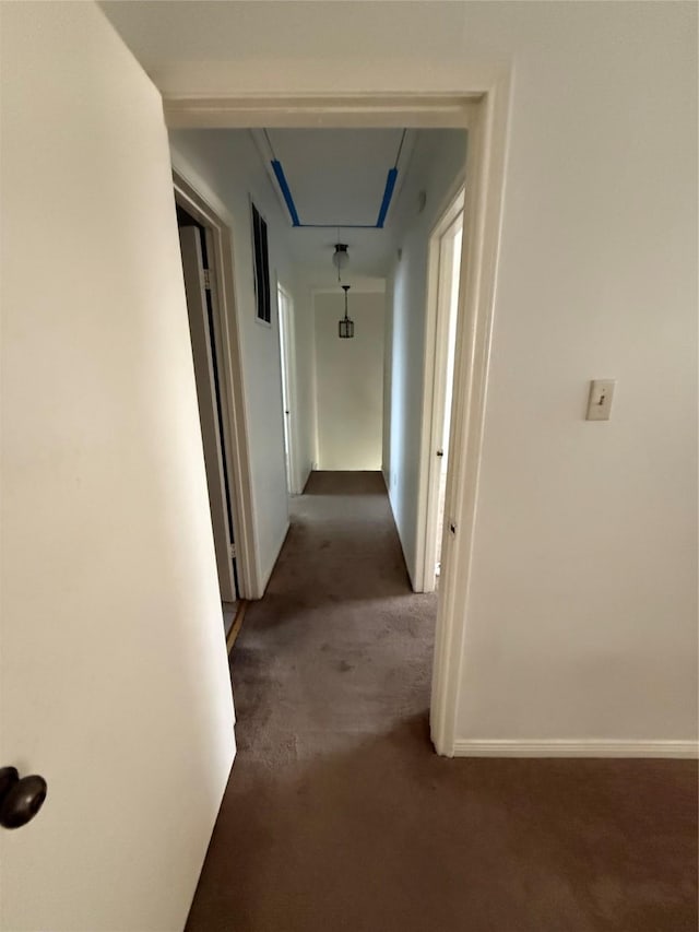 hallway with dark colored carpet