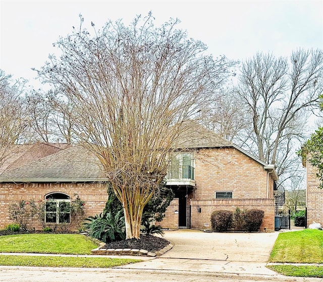 view of front of home featuring a balcony and a front lawn